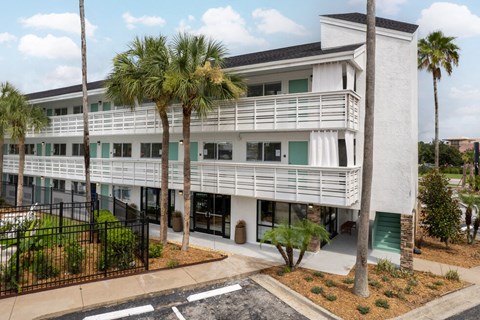 a large white building with palm trees in front of it at The Teale, Kissimmee, FL, 34746